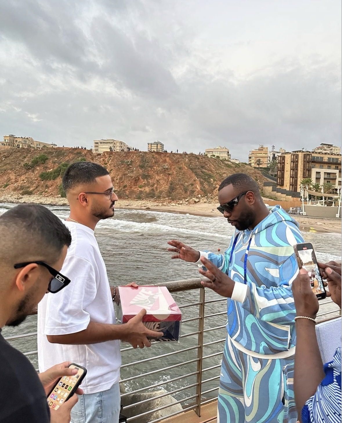 Kevin Aoun handing a Nike box to Gims on the Beirut seafront
